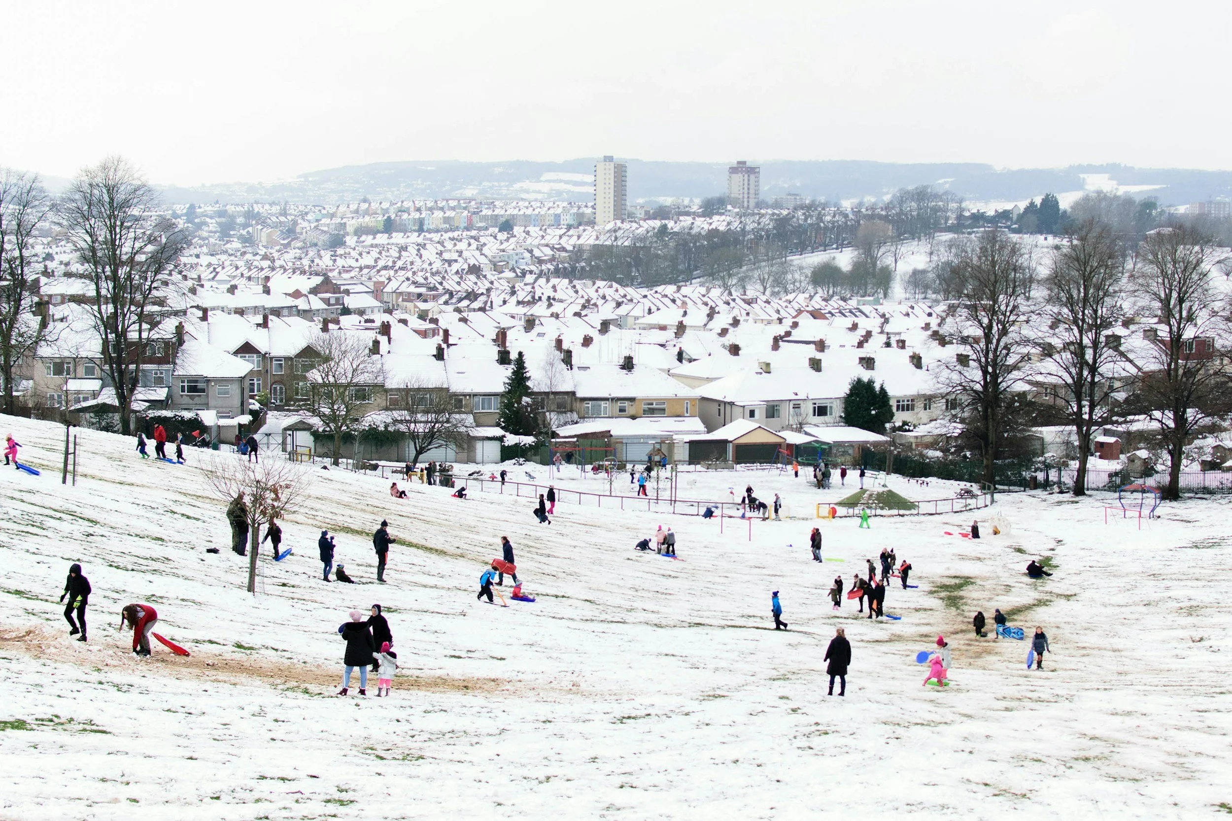 a bun ch of people playing on a snowy hill