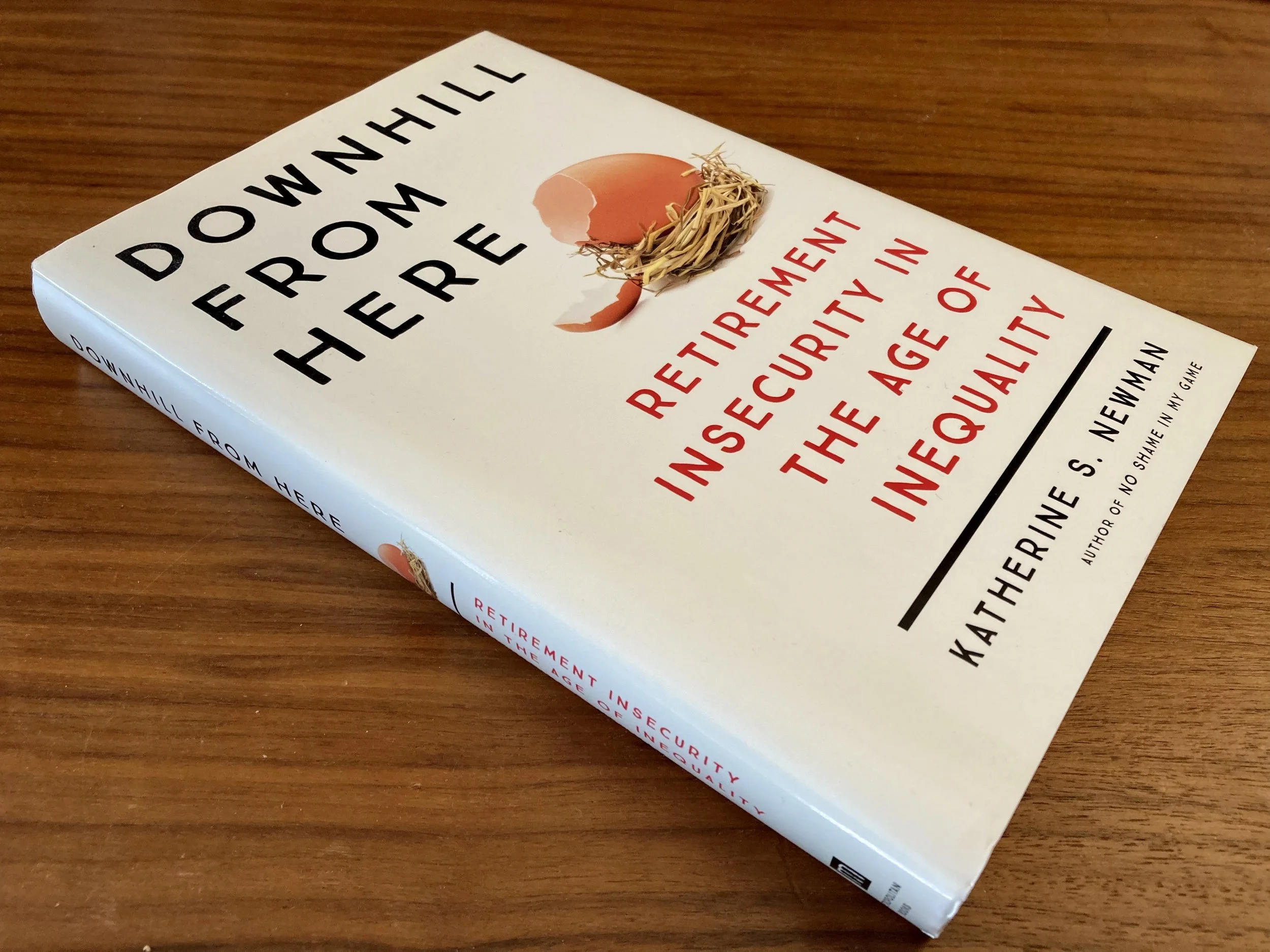 Book titled 'Down in Her Ear' with subtitle 'Retirement insecurity in the age of inequality' by Katherine S. Newman, placed on a wooden surface.