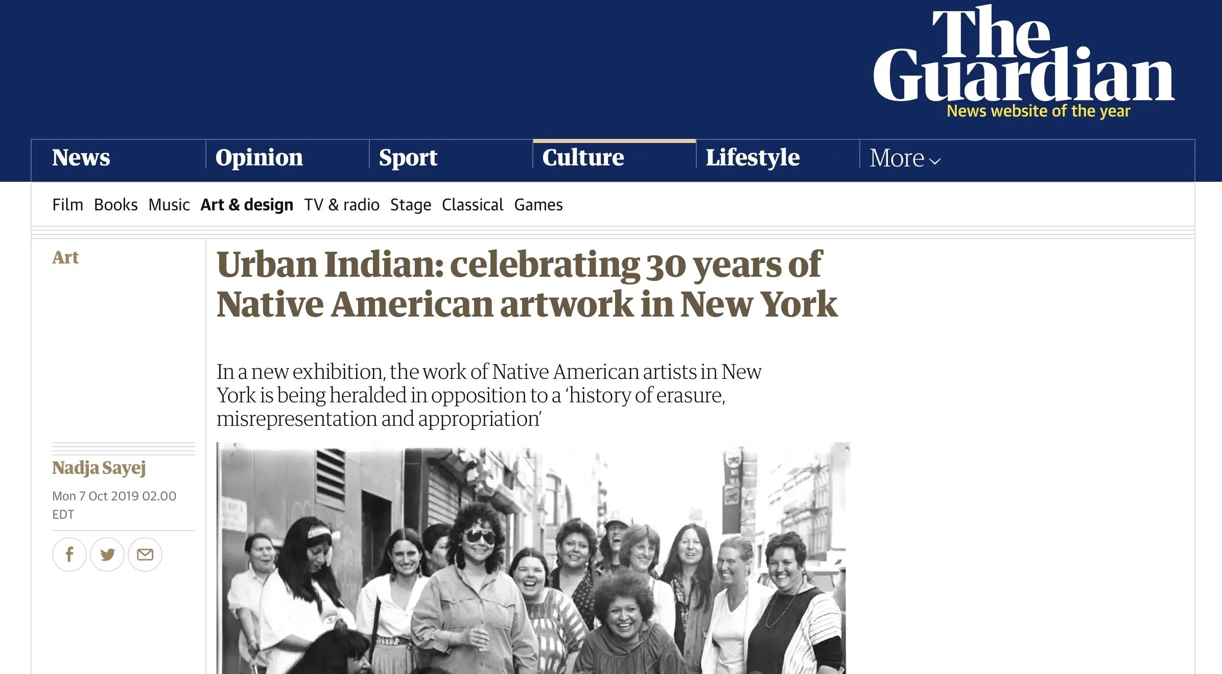 Black and white photograph of a diverse group of women smiling and standing close together on a city street.