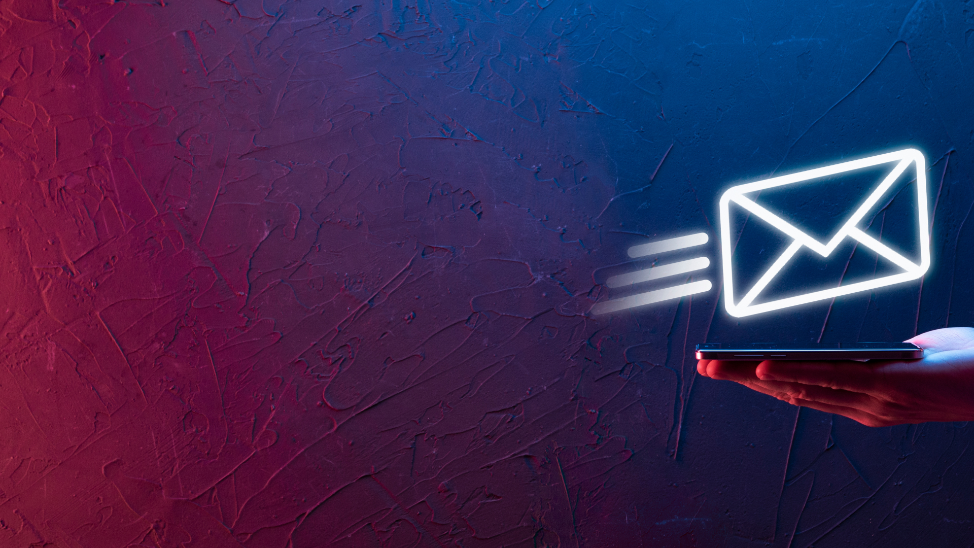 A hand holding a smartphone with a neon light emitting an envelope icon, symbolizing an email or message, in front of a textured wall background.