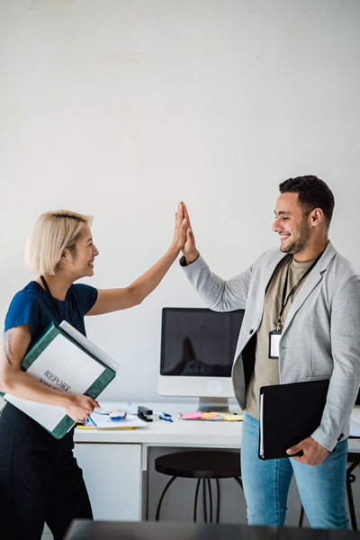 Two people congratulating each other after a successful computer support request.