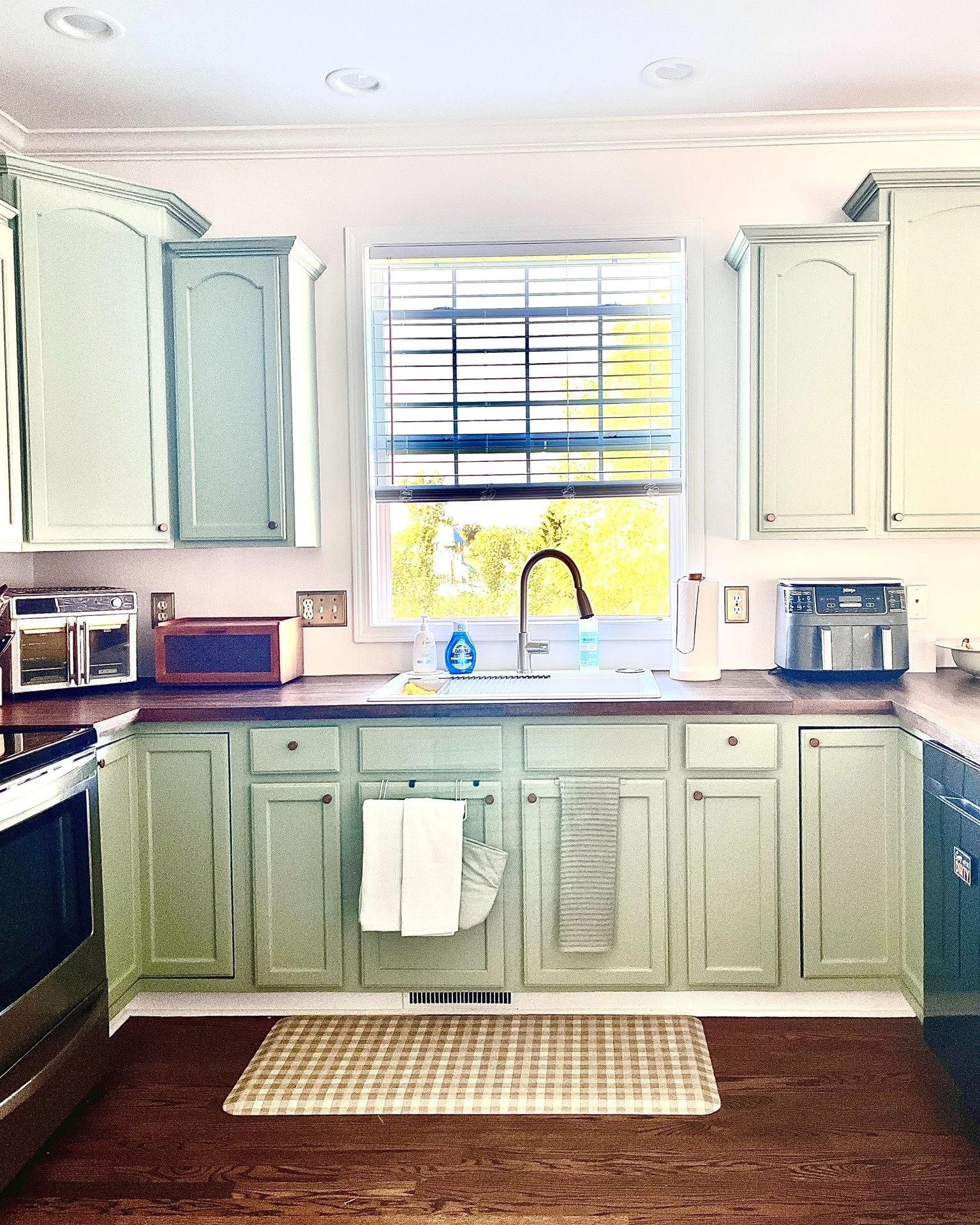 A first look at this kitchen COMPLETED! And a peek at the custom dining space beside it.

Soft green cabinets, refinished wood floors, a redesigned island, and a custom built-in with a coffee station, wine bar, and window seat. Every detail was desig