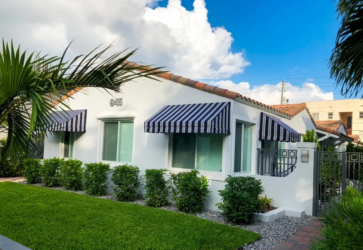 White house with striped awnings at 645 Lenox Ave, Miami Beach