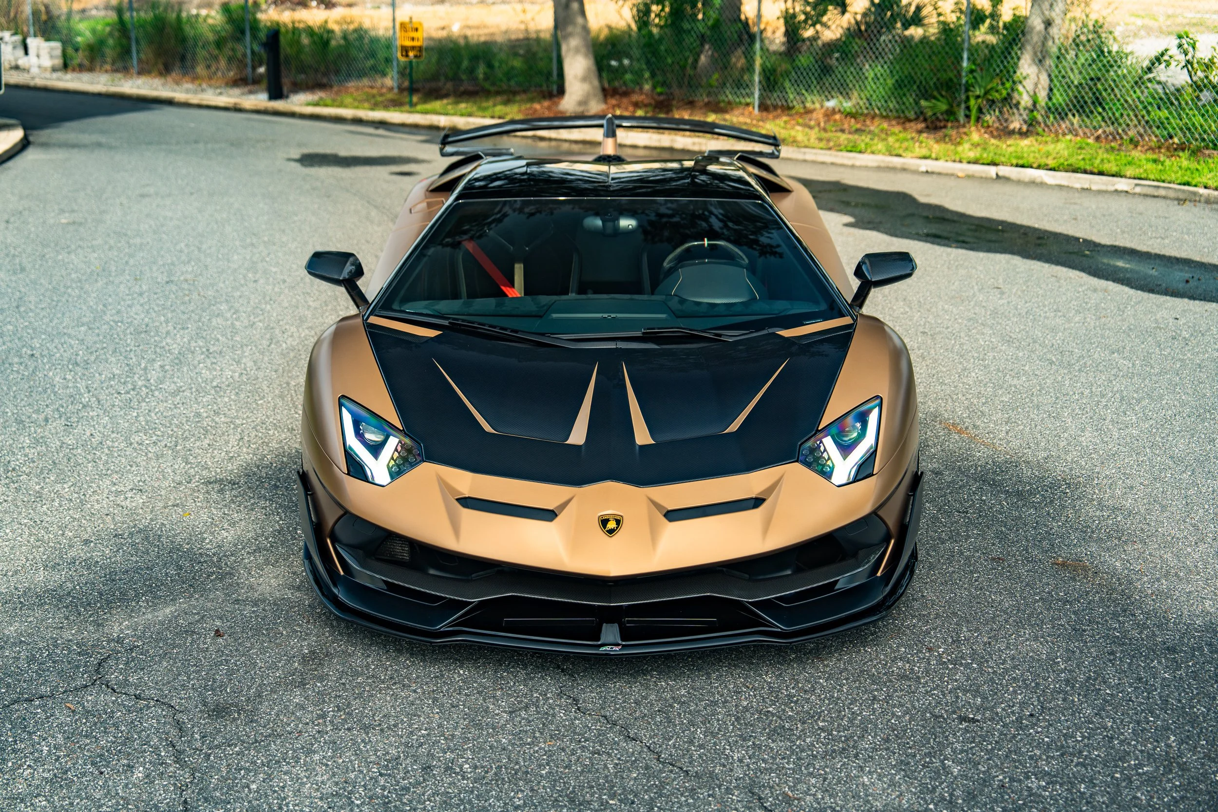 A gold and black Lamborghini sports car parked on the street.