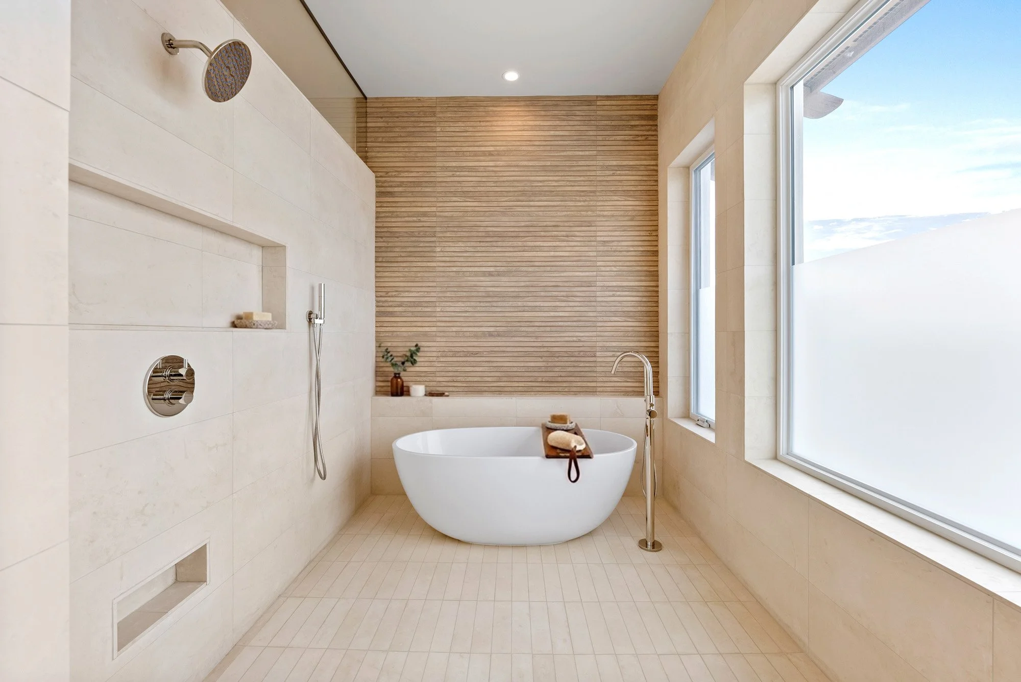 Modern bathroom with a freestanding bathtub, large windows, and a wood-paneled wall.