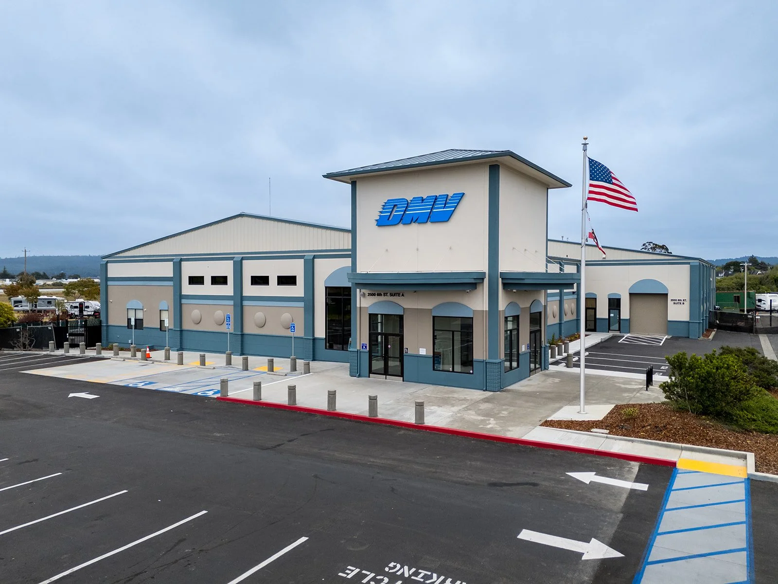 Remodel of existing building into new DMV with flagpole in front. 