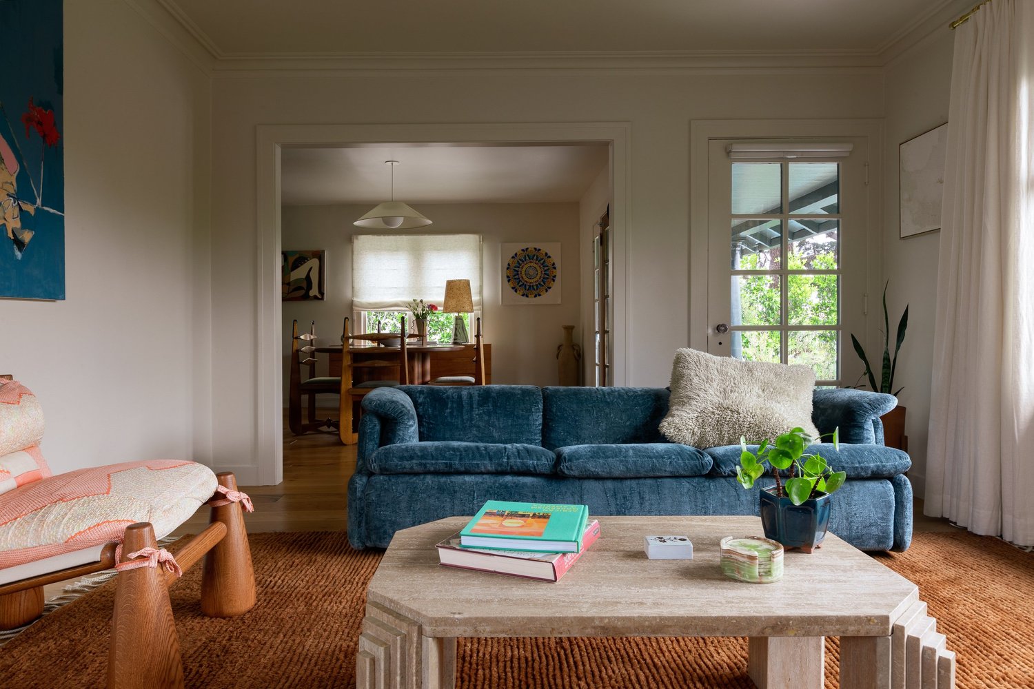 Dining room with vintage pieces, warm wood, and layered art