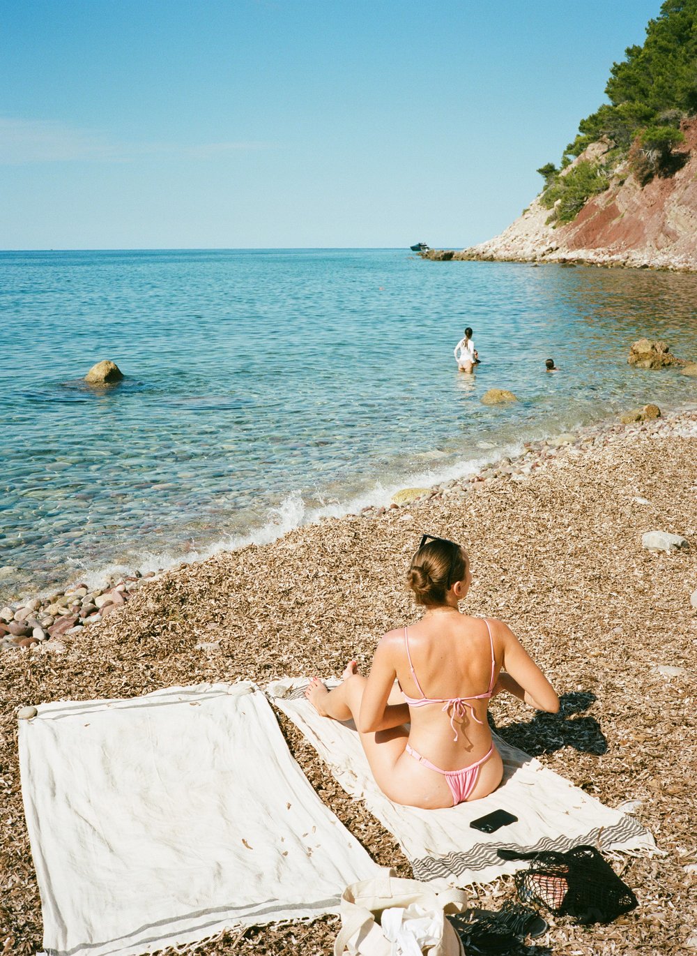  wife reading on rocky beach of Mallorca, Spain 
