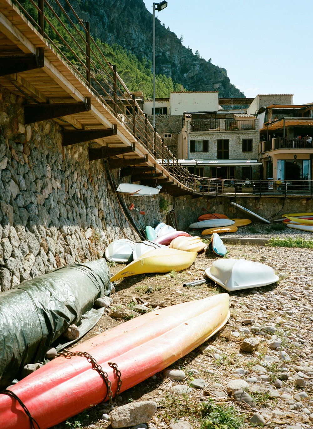 turned over kayaks and boats on rocky beach town in Mallorca, Spain 