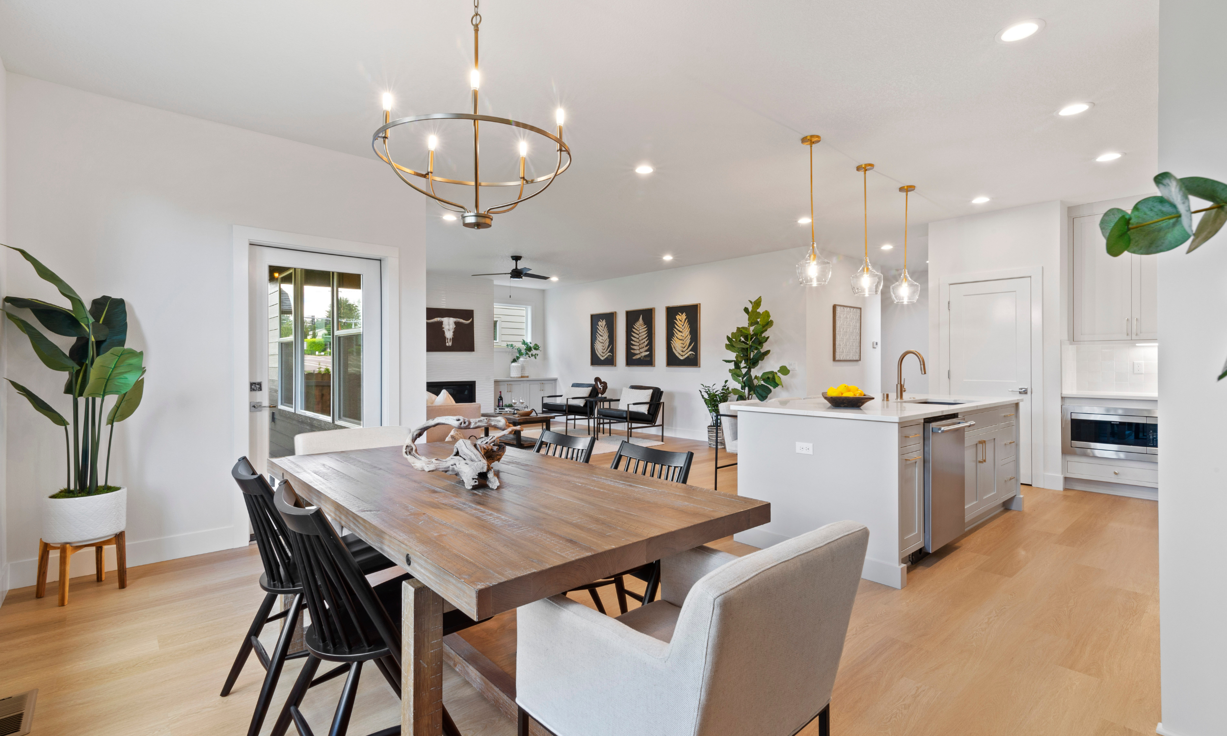 Staged open concept home looking out at dining room, kitchen, and living room