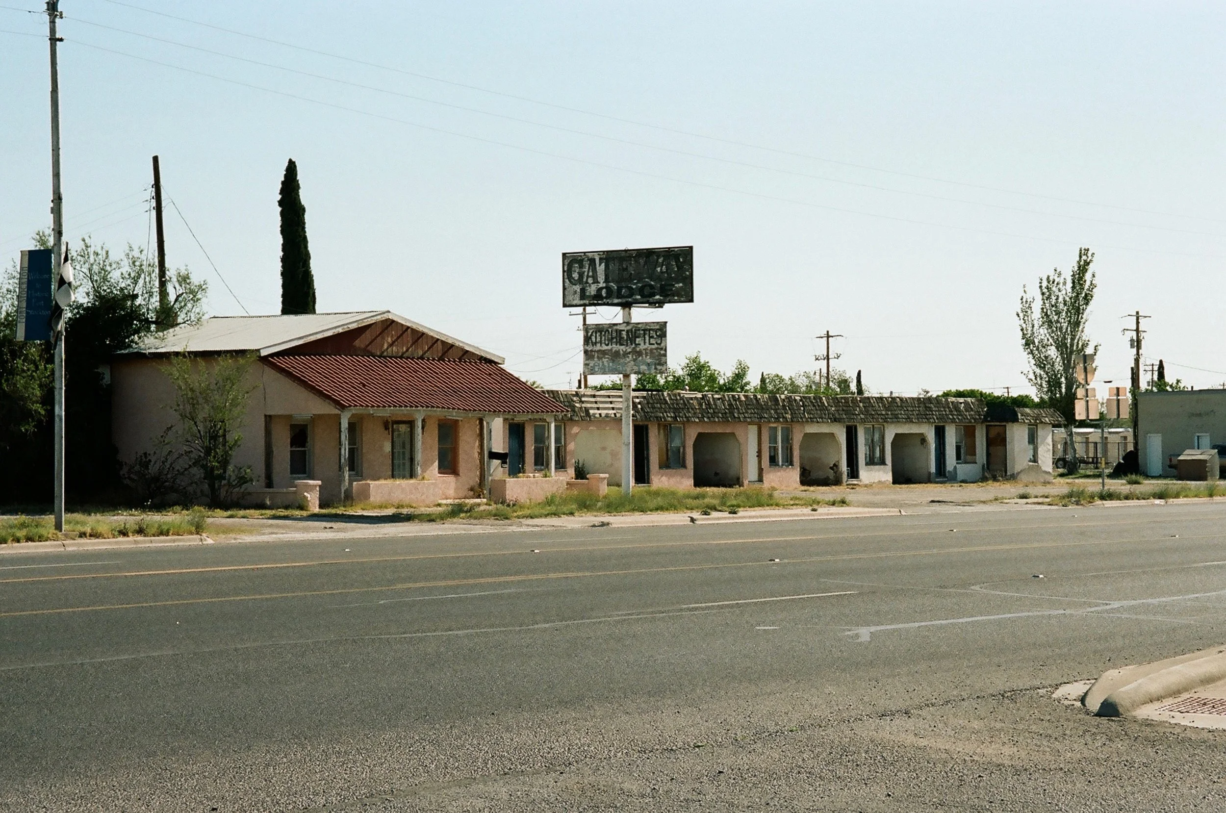 Abandoned roadside building with old signs, including 'GATEWAY' and 'LODG'.
