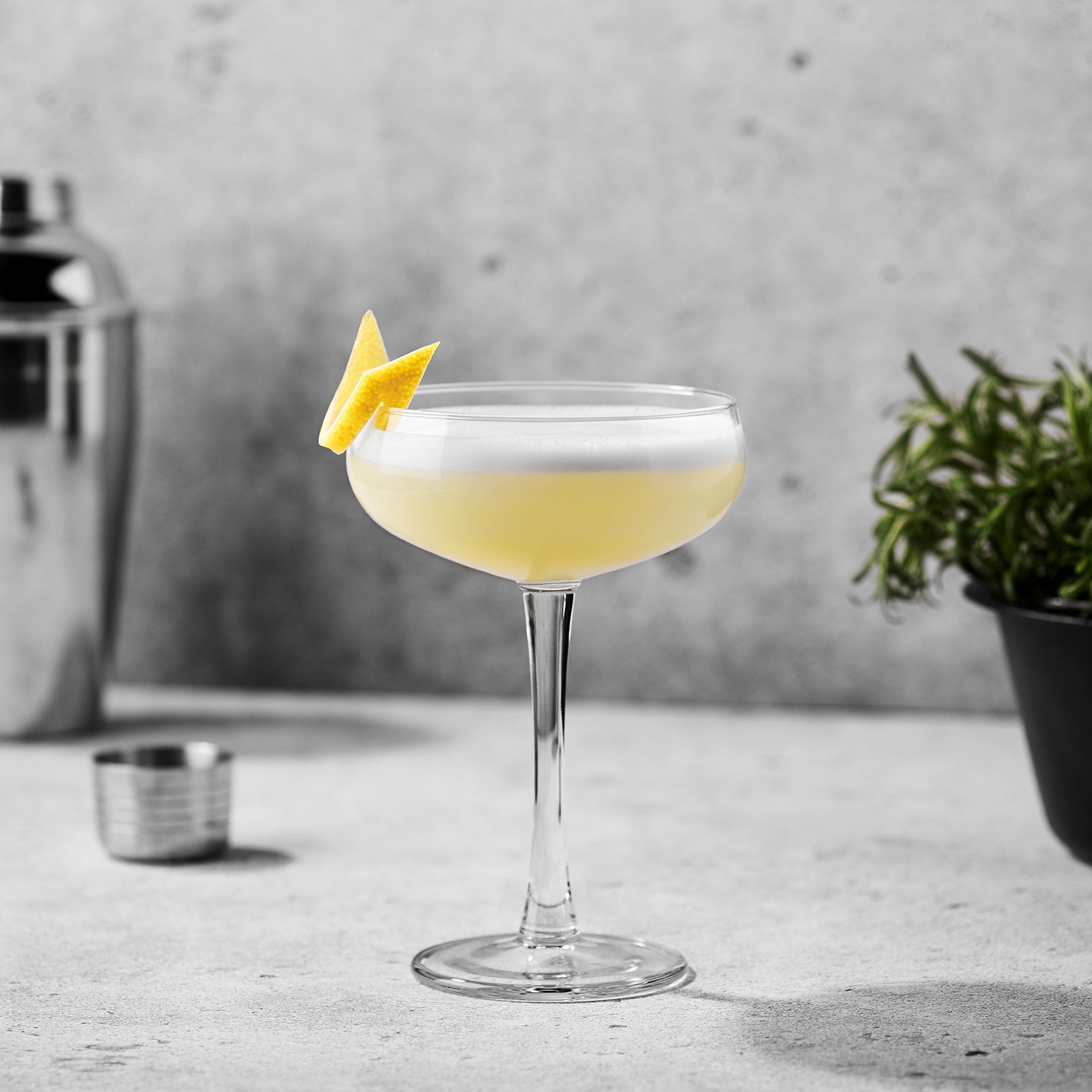Gin Sour cocktail med citron och skummigt skum serverad i coupeglas