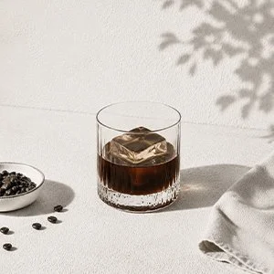 Kaffelikör över en stor isbit i glas – mörk och fyllig kaffelikör med rostade kaffetoner och elegant servering.