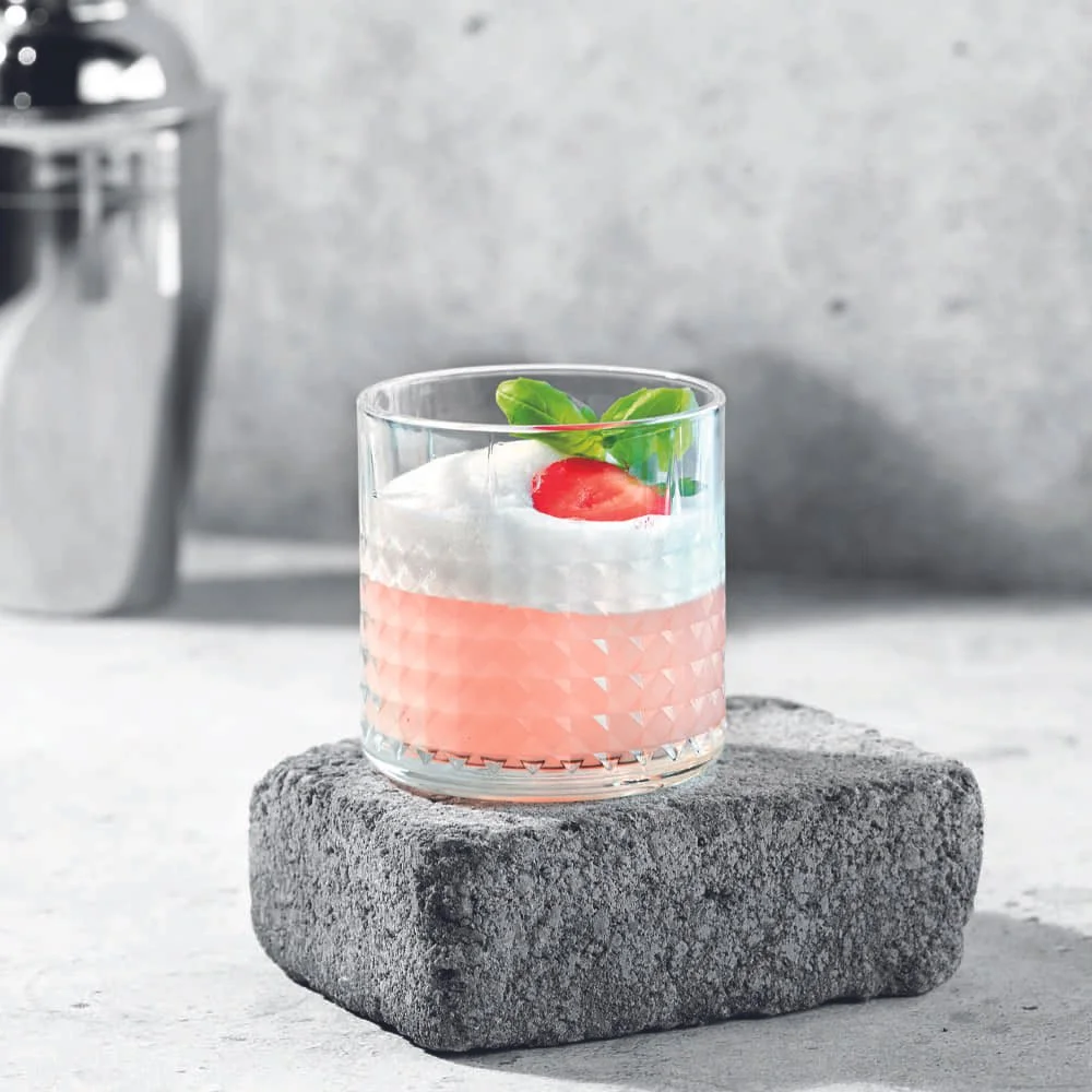 Strawberry Basil Gin Sour med jordgubbar, basilika och citron serverad i rocksglas