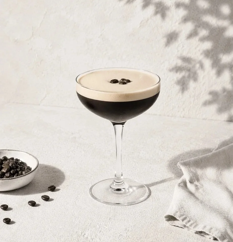 Espresso Martini i coupeglas med krämigt skum och kaffebönor på toppen – en elegant kaffecocktail med fyllig espresso och kaffelikör.
