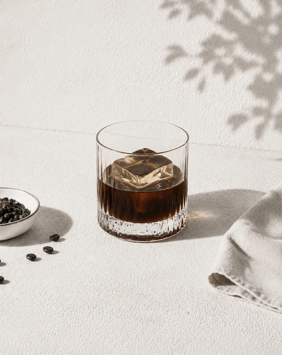 Kaffelikör över en stor isbit i glas – mörk och fyllig kaffelikör med rostade kaffetoner och elegant servering.