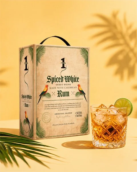 Spiced White Rum bag in box med romdrink och tropisk bakgrund i varma toner.