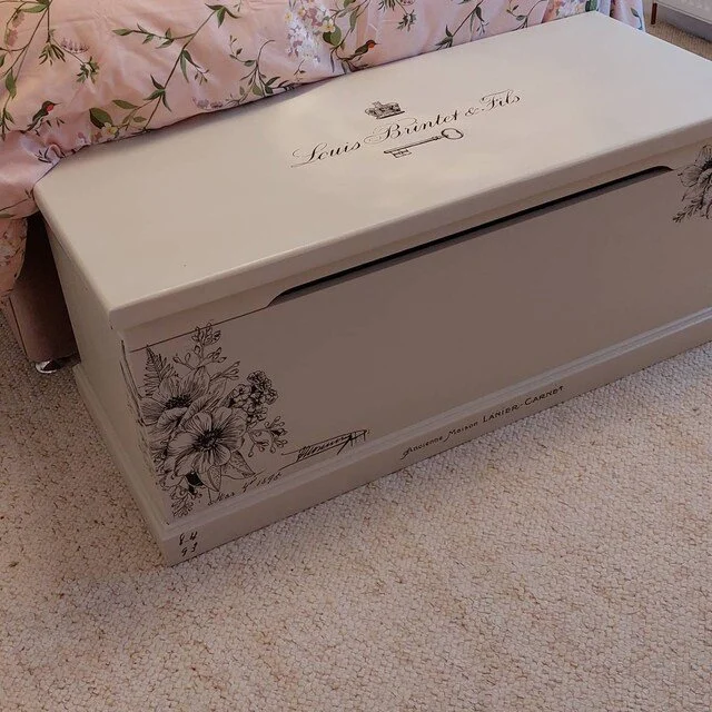 Hand painted White vintage chest with floral designs and script text .