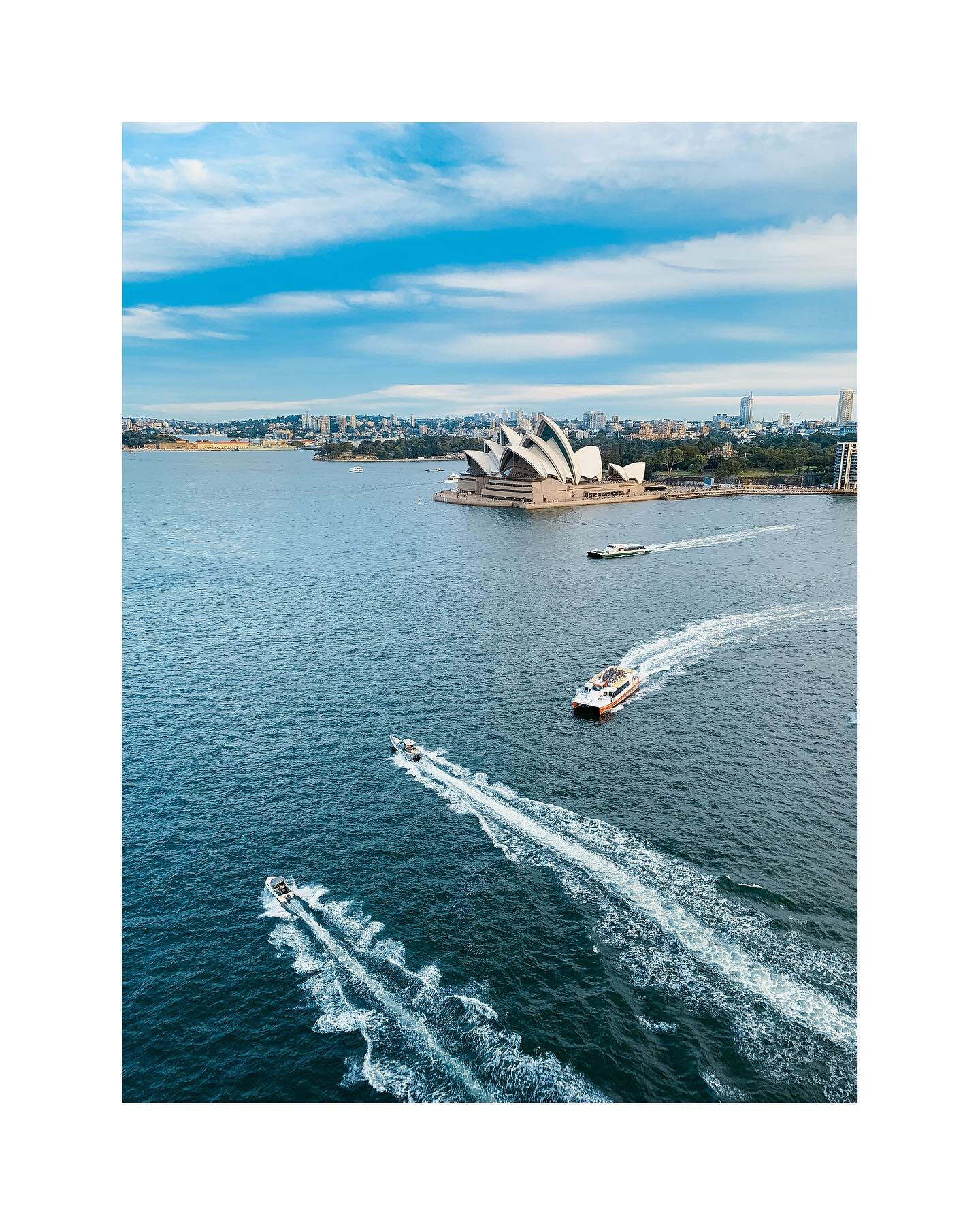 Captured from above, this image showcases the power of smartphone photography to create breathtaking compositions. The boats create intriguing lines that balance the framing and the curved architecture of the Sydney Opera House and the fluidity of th