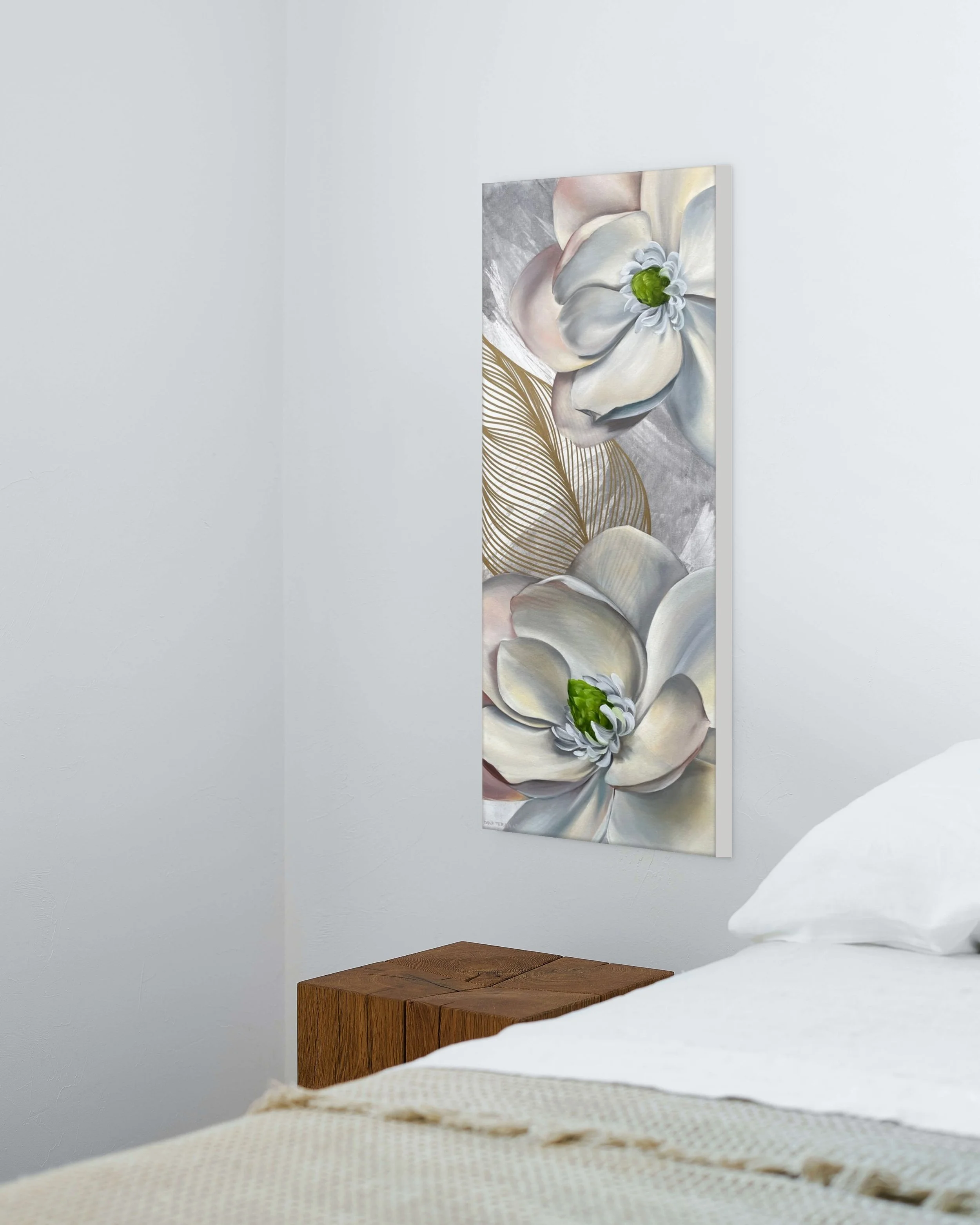 Vertical white magnolia oil painting with gold detail by Dana Teruya Len, styled above a bedside table in a calm, neutral bedroom.
