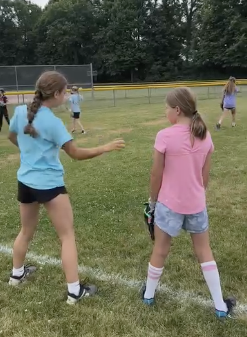 Girls playing softball on a grassy field
