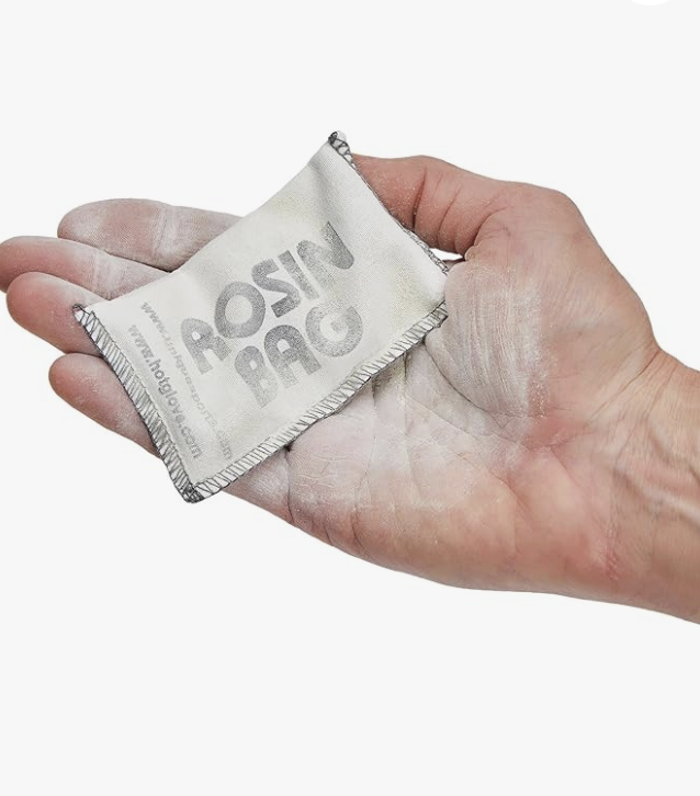 A hand holding a cloth cleaning rag with some flour residue on it, with a white background.