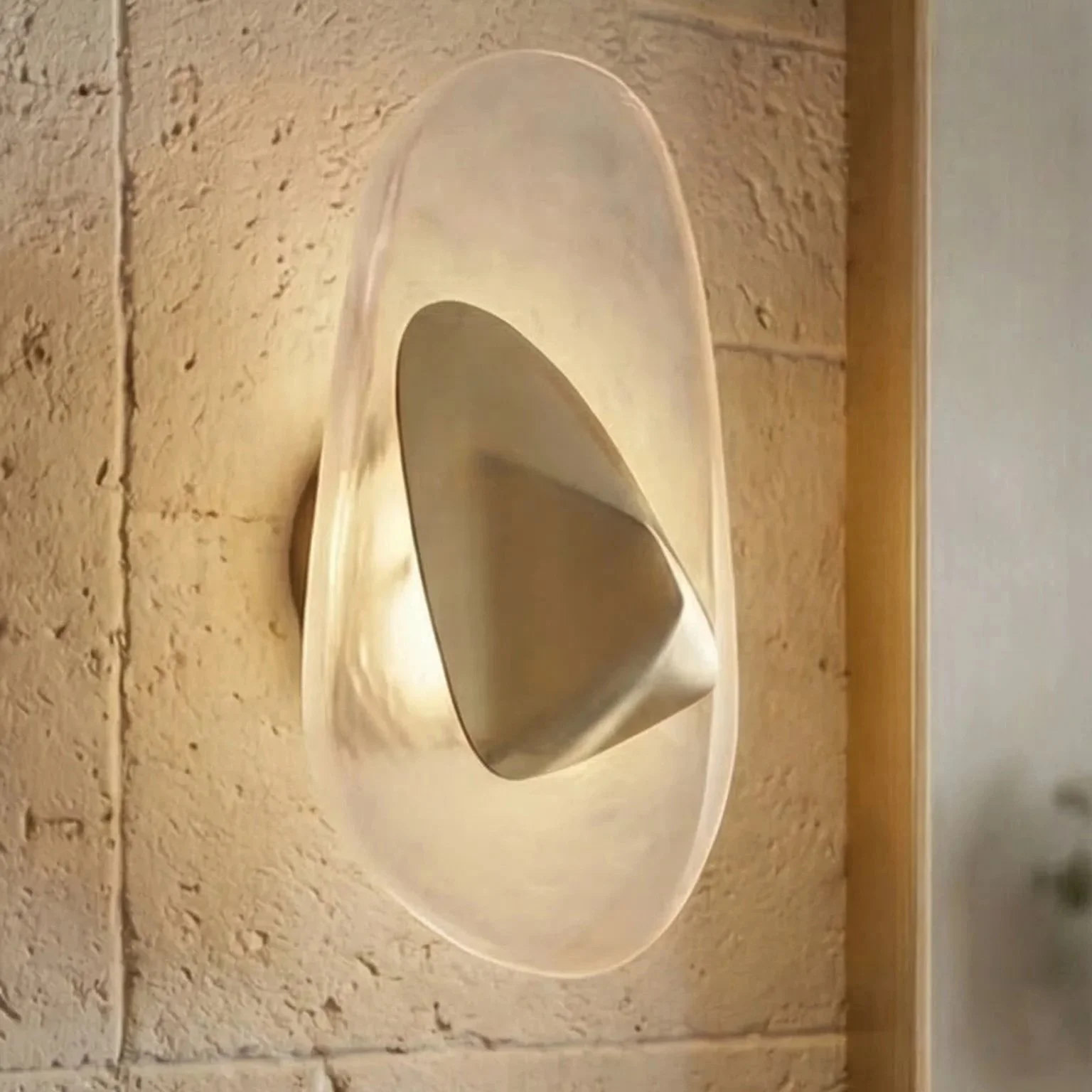 A rounded wall-mounted light fixture with a metallic cone-shaped interior, installed on a brick wall with a wooden trim on the right side.