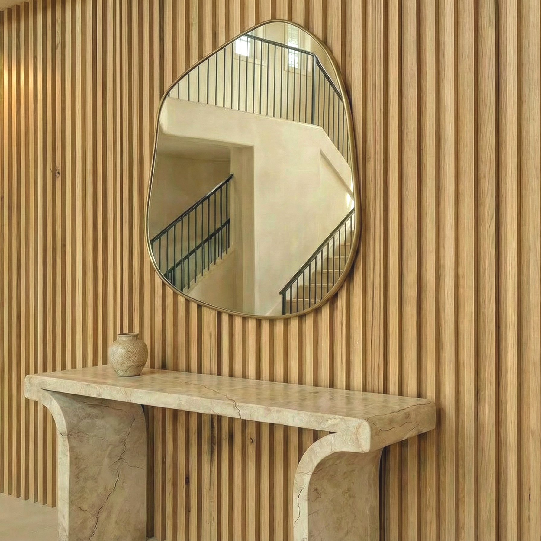 Mediterranean house. Mirror reflecting a staircase with black railings on a wooden wall.