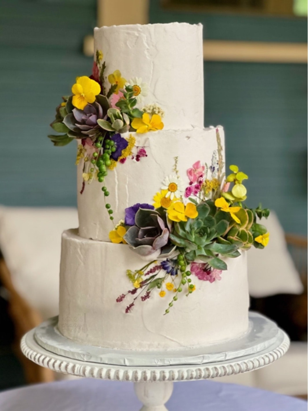 KatesCakes_tiered cake with floral accents.png