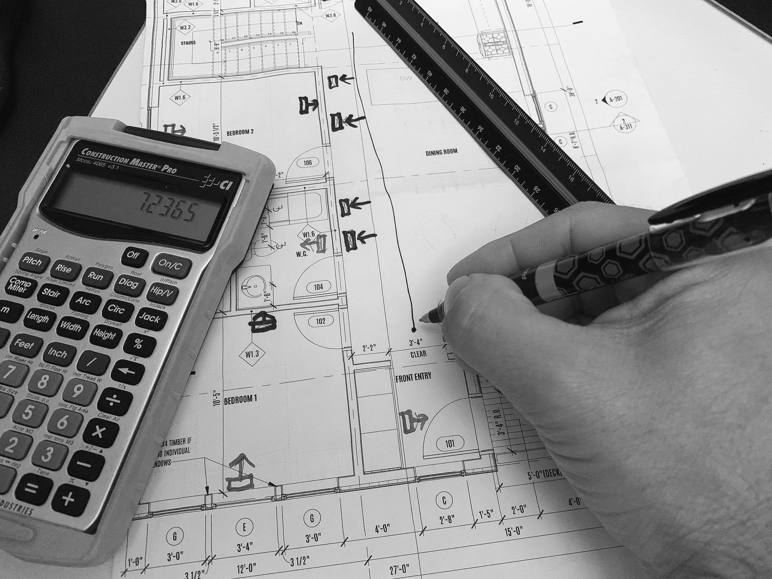 Floor Plan, scale ruler, calculator, pen in hand.
