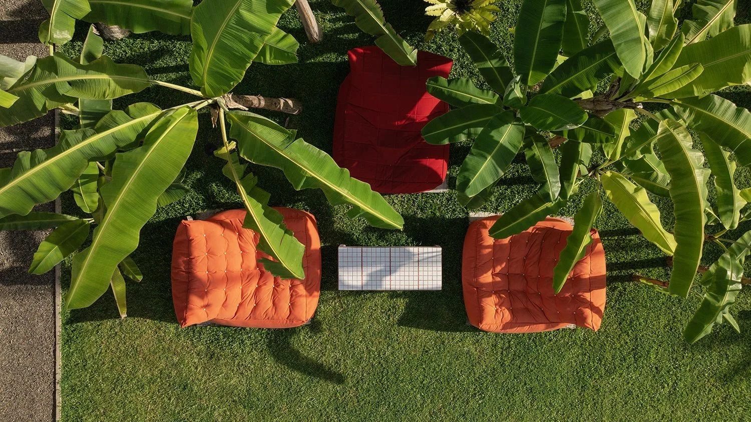 Aerial view of outdoor seating with orange chairs surrounded by banana trees — Casa Tikiri Boutique Hotel, Ahangama, Sri Lanka