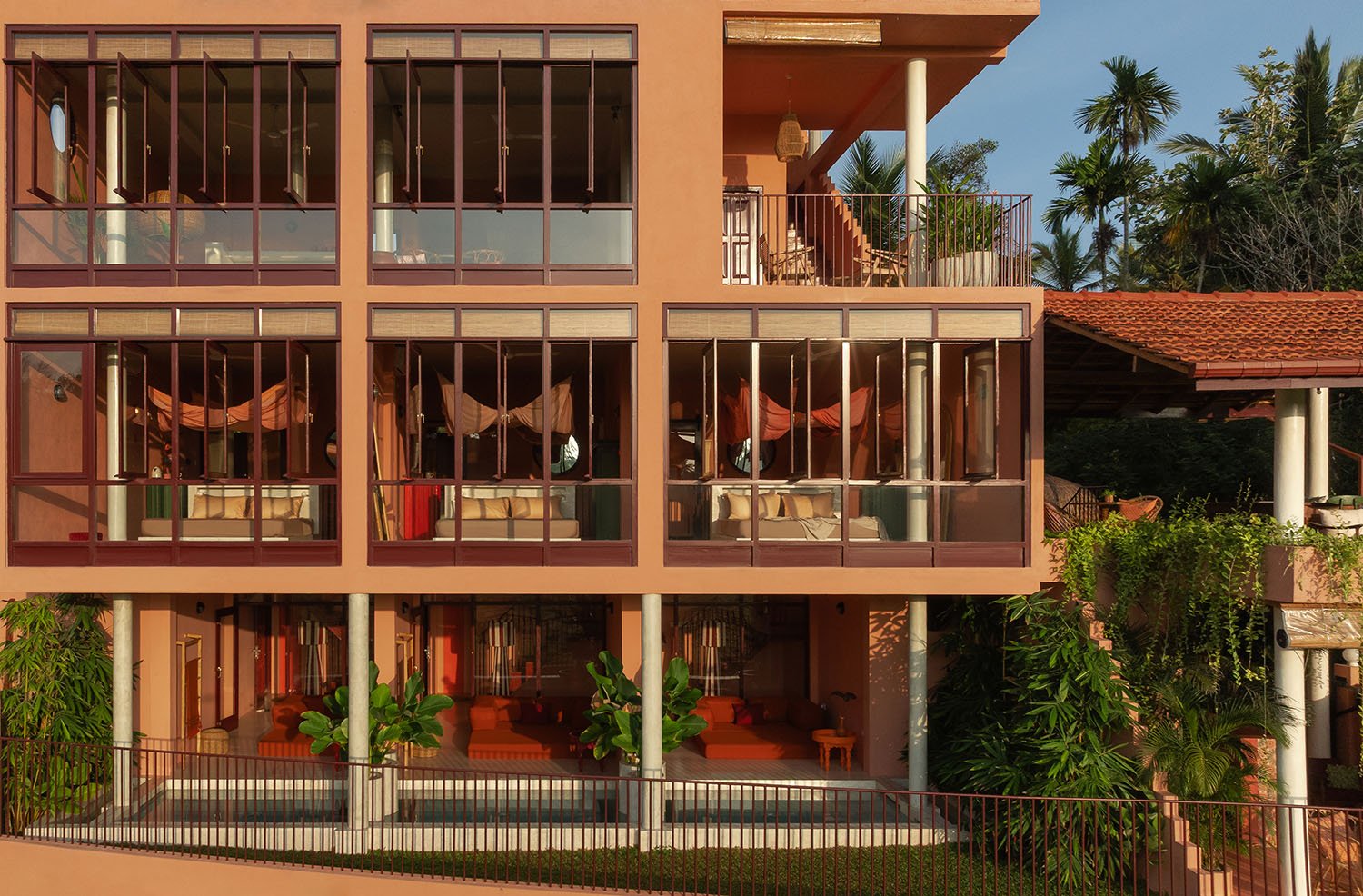 Multi-story building with glass windows and balcony among lush green plants — Casa Tikiri Paddy Lodge, Ahangama, Sri Lanka