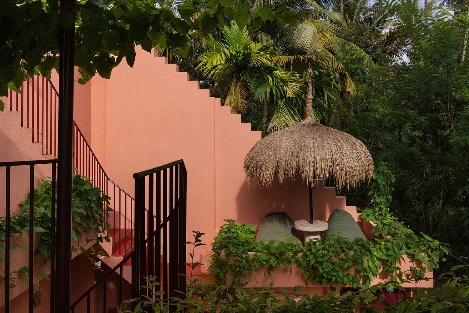Pink building with staircase and thatched umbrella — Casa Tikiri Paddy Lodge, Ahangama, Sri Lanka