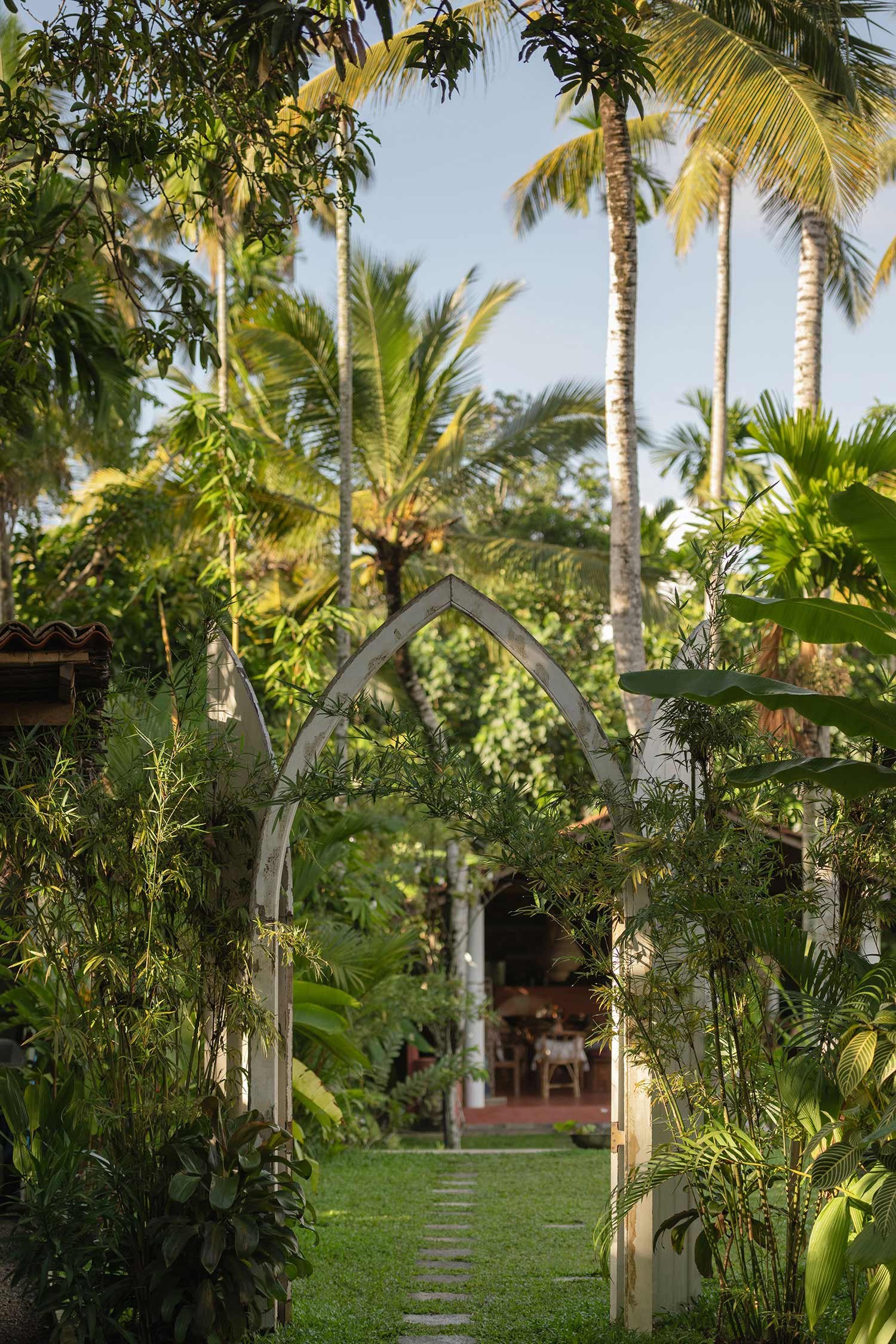 Garden pathway of stepping stones leading to an arched white garden door— Casa Tikiri Boutique Hotel, Ahangama, Sri Lanka121