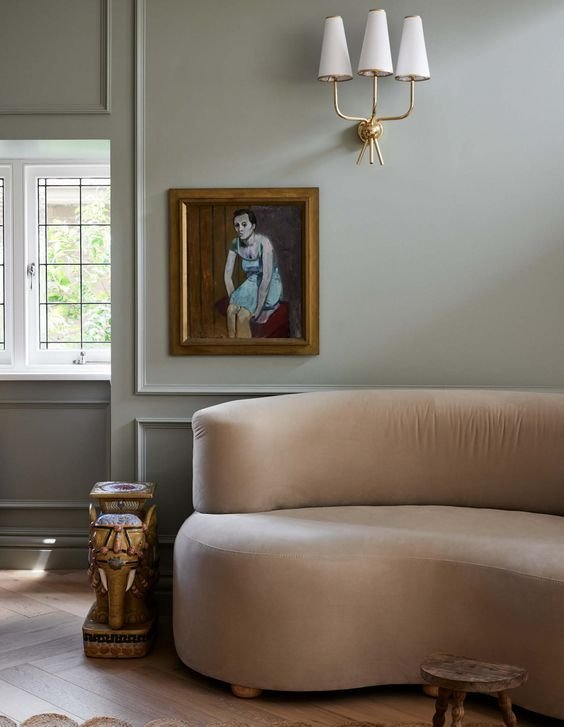divano curvo beige con quadro antico
