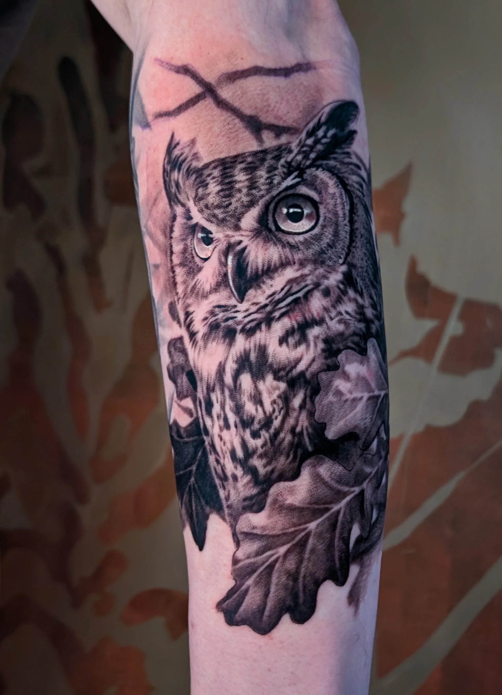 tattoo of realism owl portrait with oak leaves