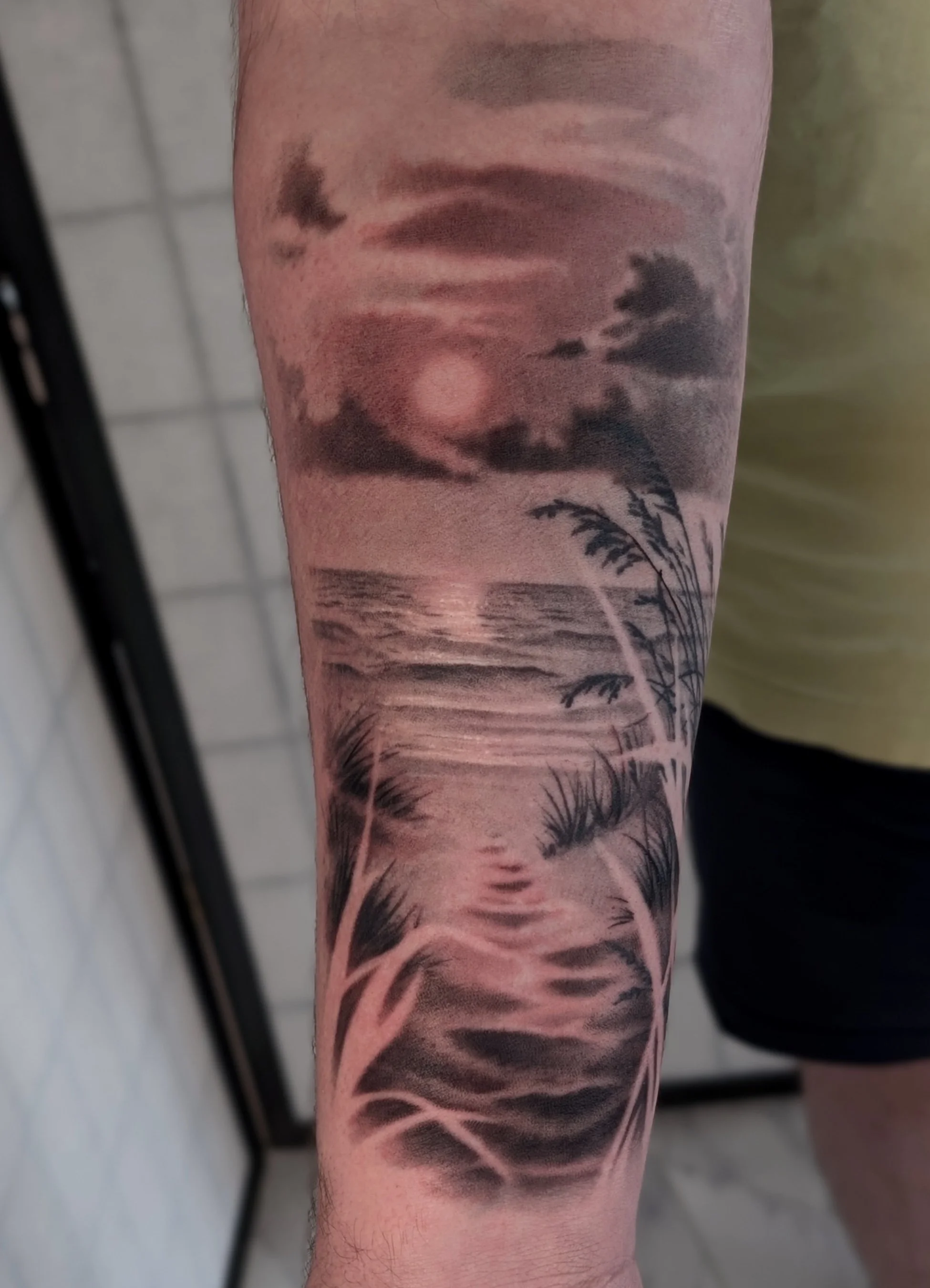 Tattoo of serene beach landscape with sunrise