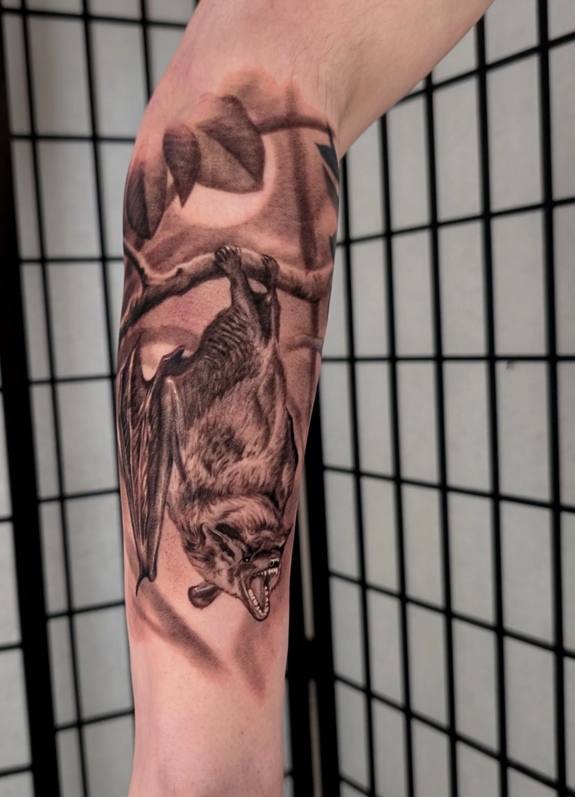 tattoo of bat hanging in the trees on a moonlit night