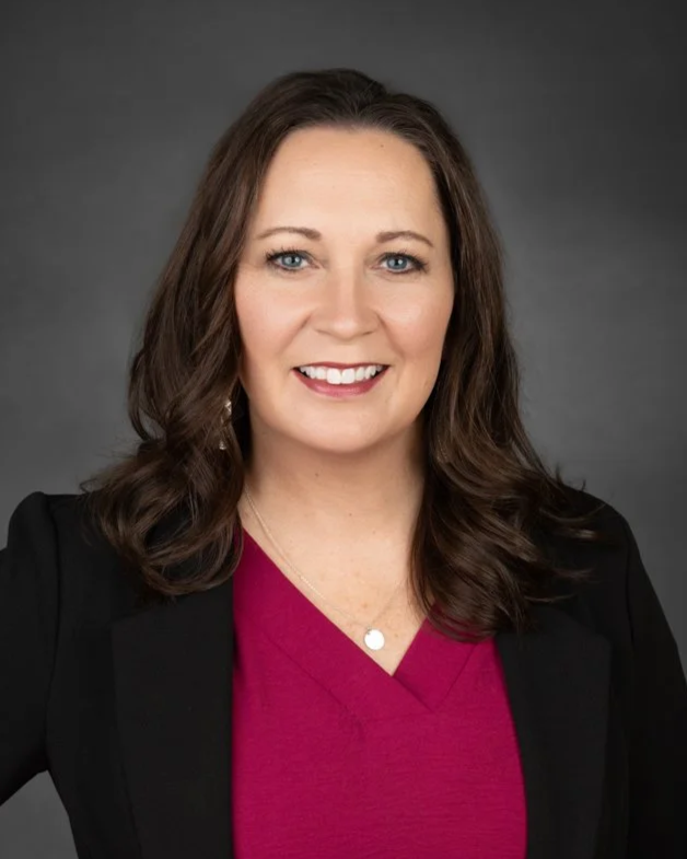 woman red blouse black jacket smiling headshot