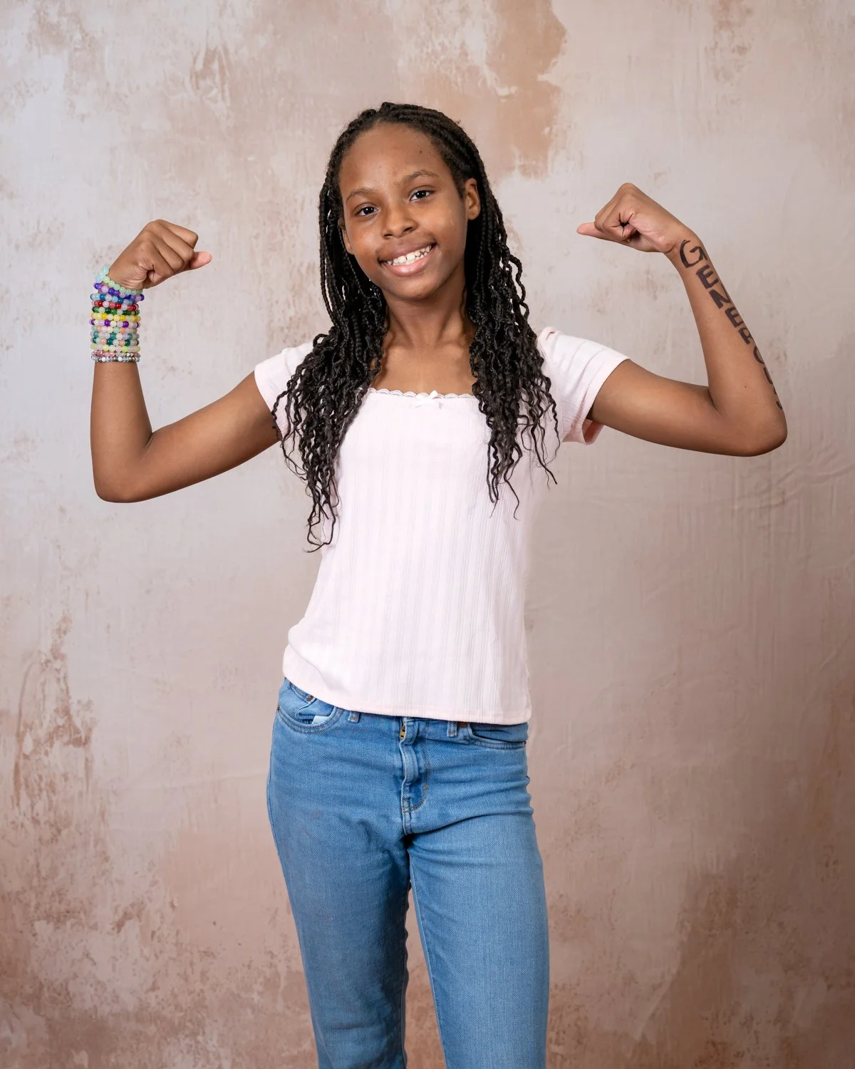 Girl with the word Strong on her arm