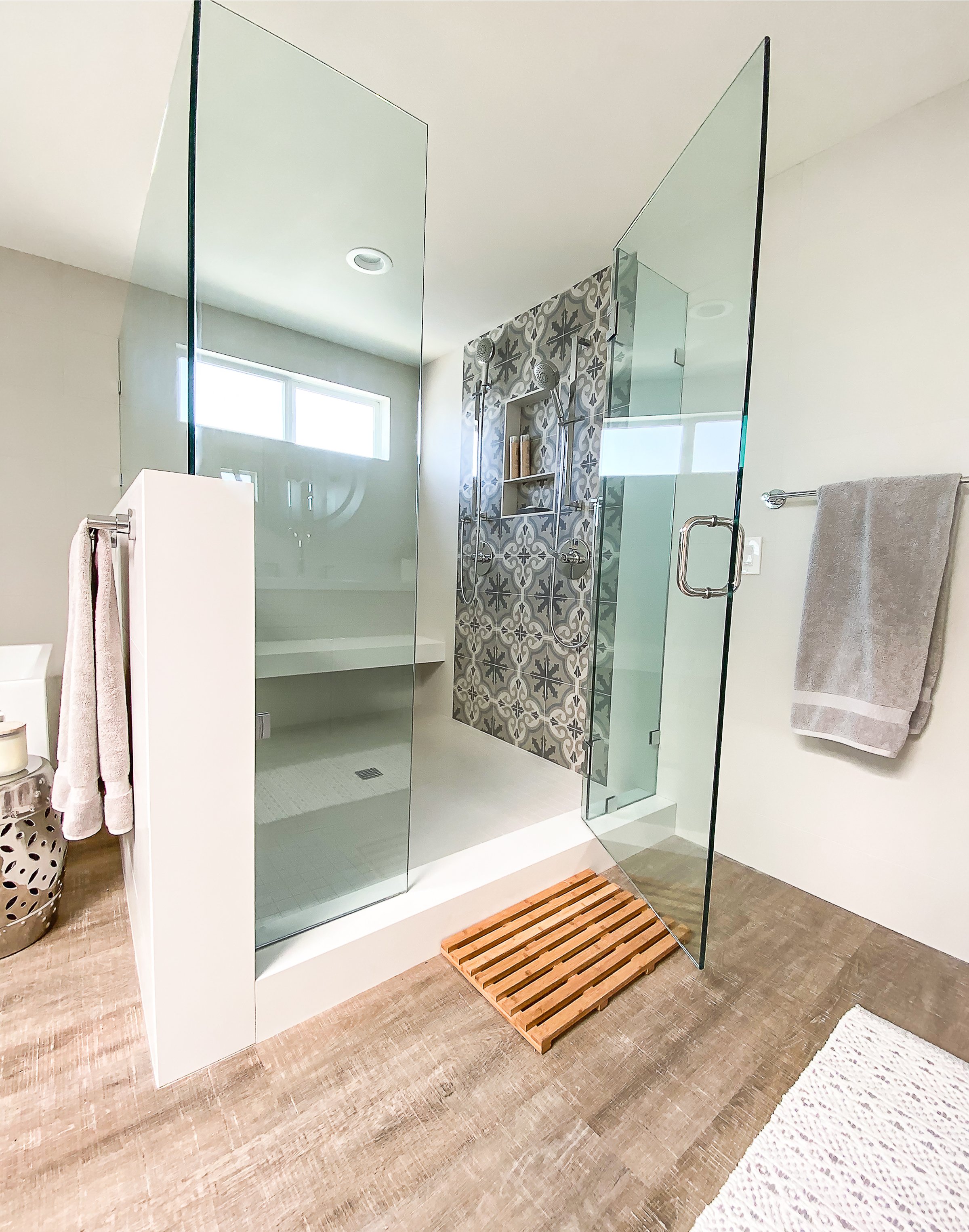 Walk in shower with dual shower zones, floating quartz composite bench and featured tile work with built in niche.