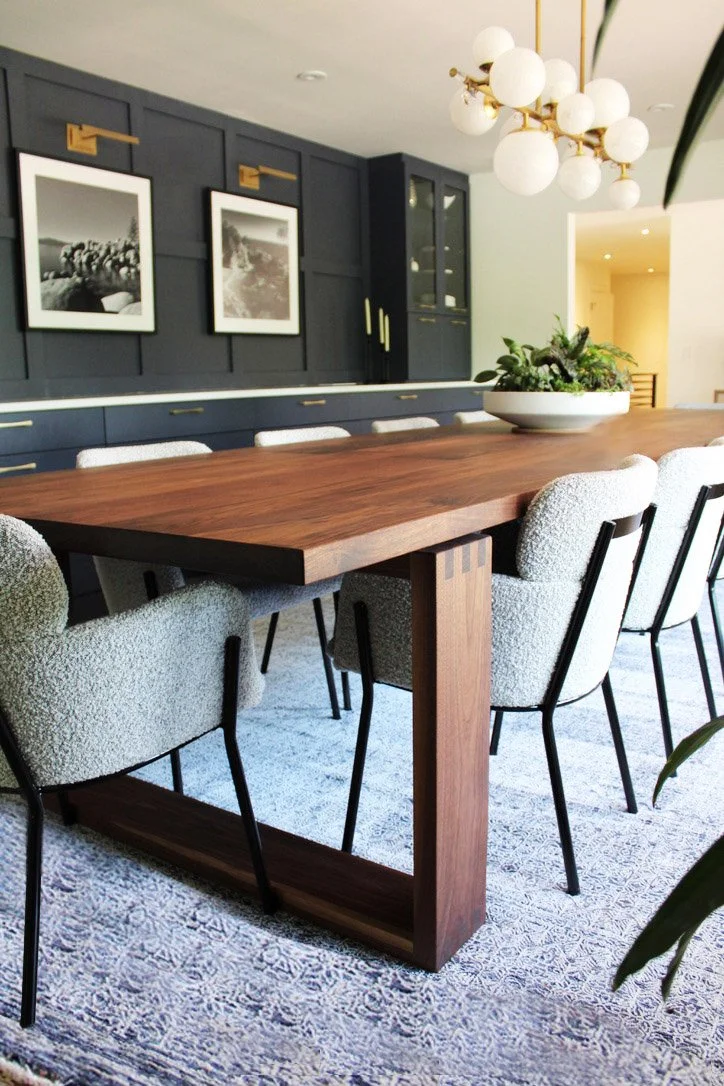 Modern Dining Room with custom made dining table, wide comfy chairs, custom build in wall to wall cabinetry, custom drapes and framed black and white photography. Fresh plants and minimal decor gives the space a clean, welcoming feel. Perfect for lar
