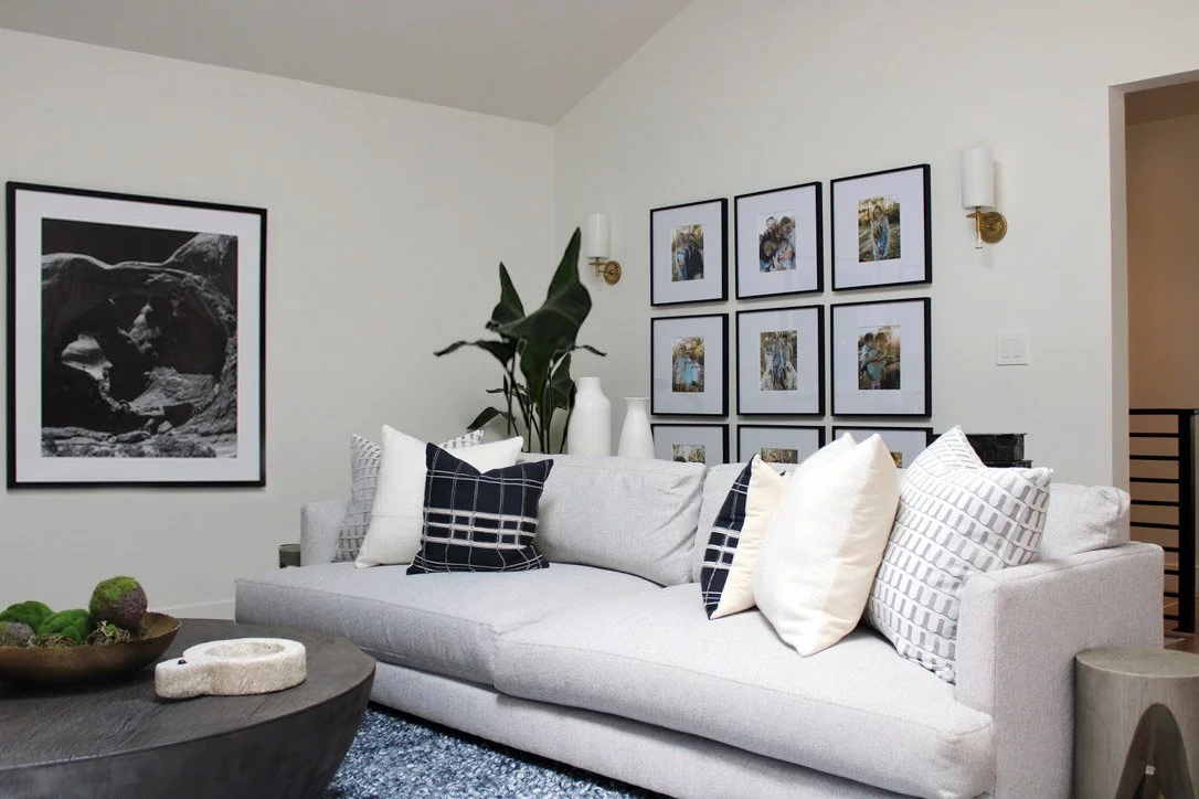 Our client is an amateur photographer so we made sure to include some of his work throughout the home in our Cherry Hills modern living room makeover. Oversized black and white photography on the back wall and a collage of family photos flank the nic
