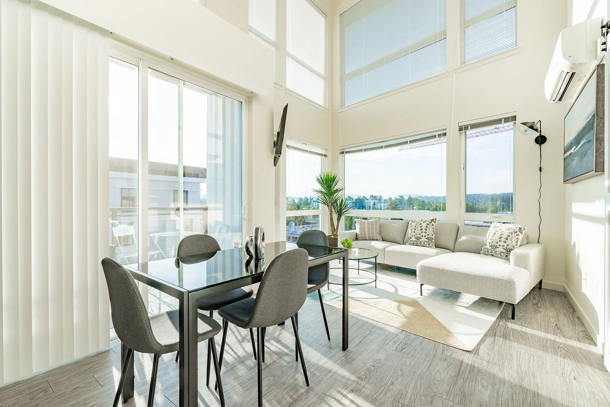 Living room and dining area with double height windows and views.jpg