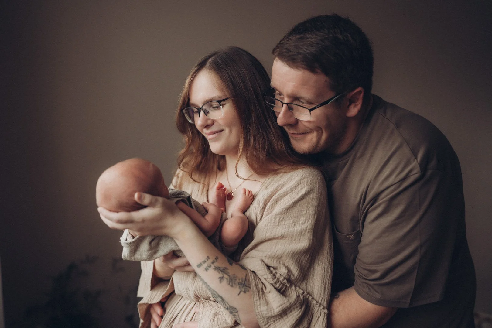 Eltern halten glücklich ihr neugeborenes Baby im Arm.