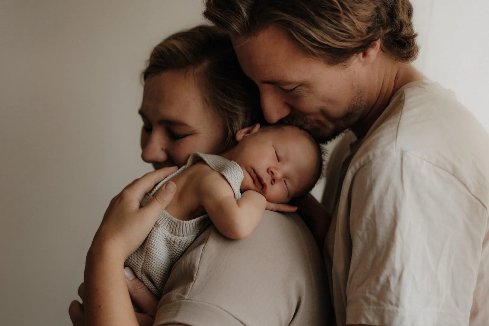 Neugeborenes Baby schläft auf Mamas Schulter.