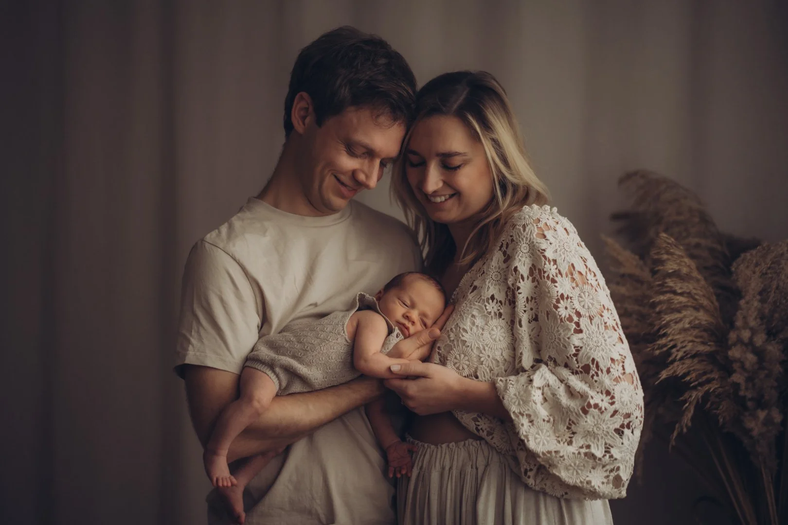 Eltern halten ihr Neugeborenes Baby auf dem Arm.