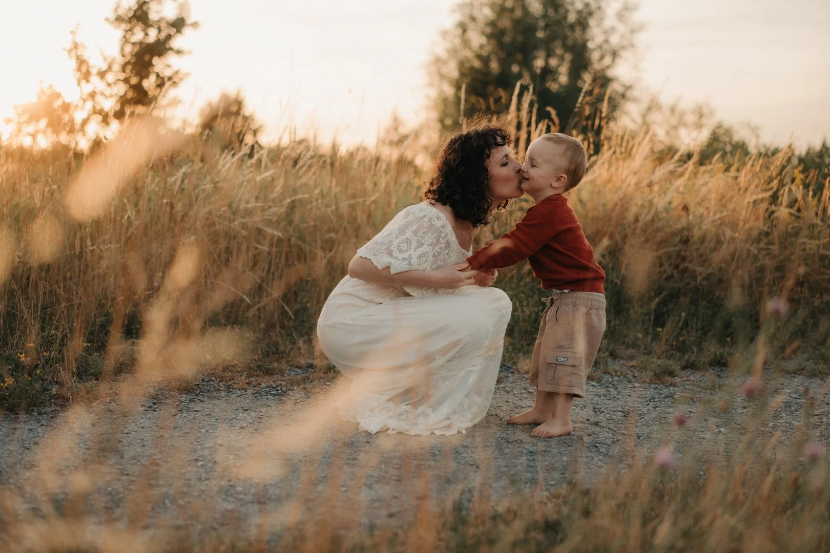 Mama und ihr Kind kuscheln im Abendlicht.