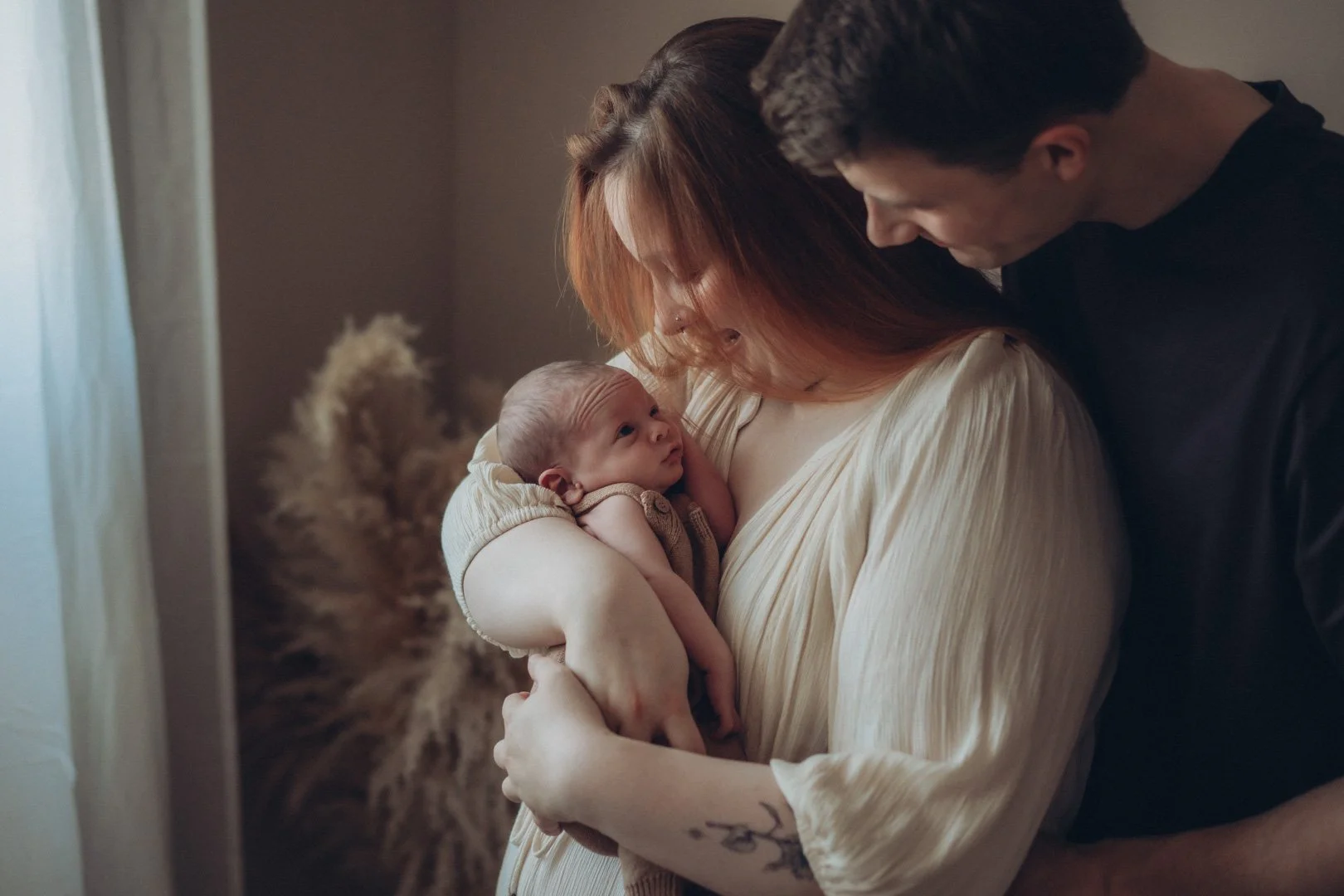 Eltern halten ihr Baby glücklich im Arm.