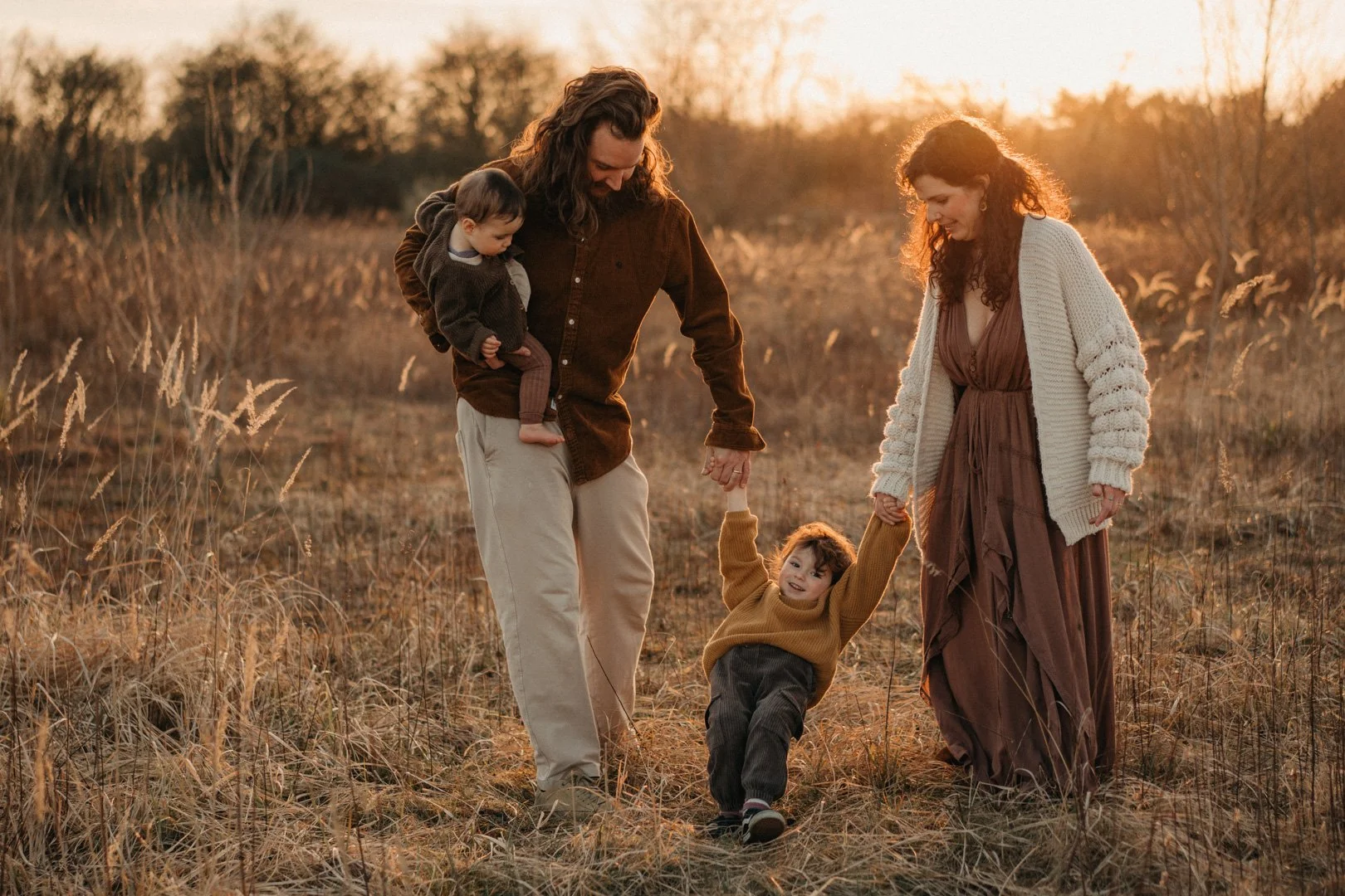 Familie hält sich an den Händen beim Gehen.